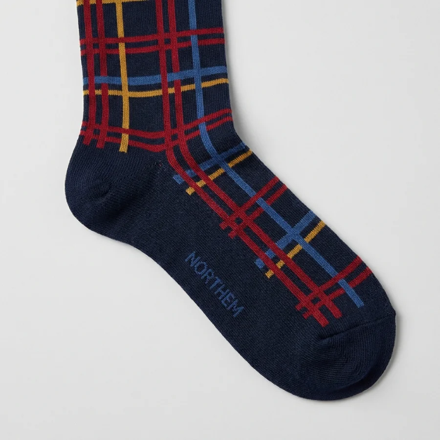 Custom navy crew socks with a red, gold and blue plaid pattern and a woven NORTHEM logo
