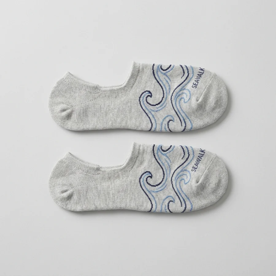 A pair of custom grey no-show socks with a blue wave pattern and a woven SEAWALK logo